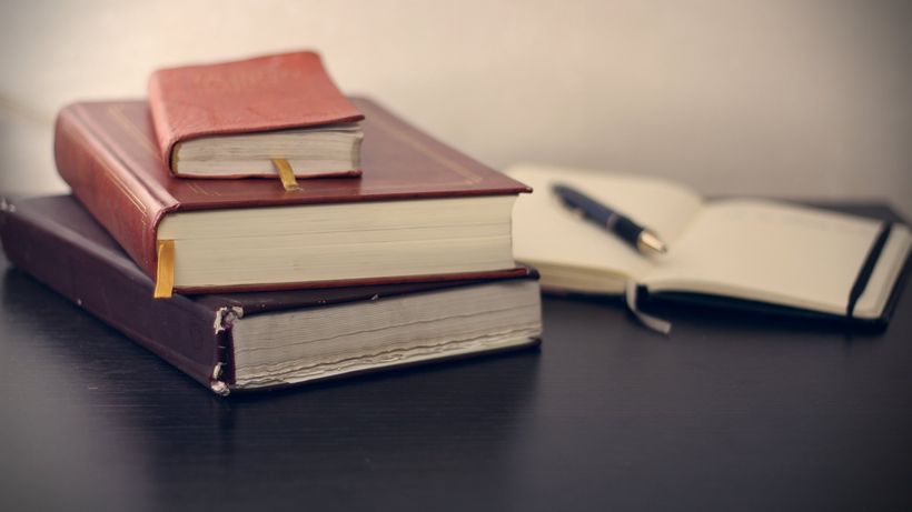 Books, pen and notepad on a desk